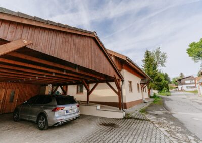 Exteriér Apartmáru TŘI - zastřešené stání pro auta a apartmánový dům